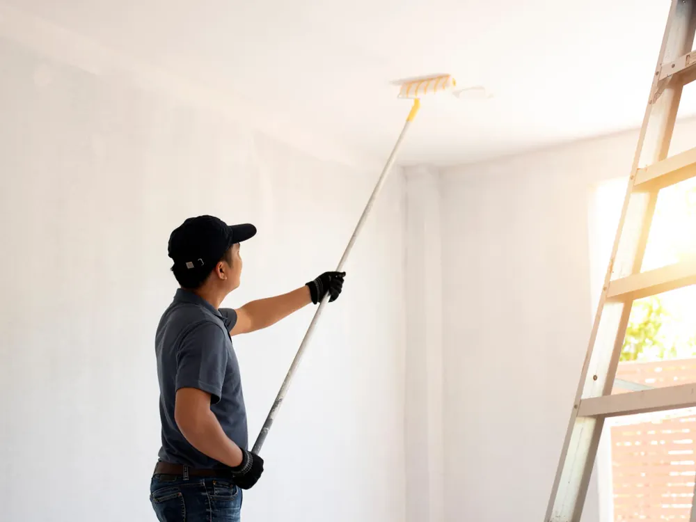 Schilder van Luxklus aan het werk aan een plafond